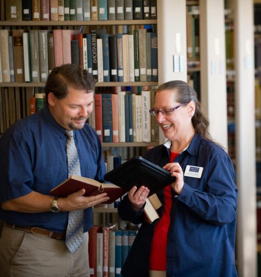 Two librarians standing in a library.