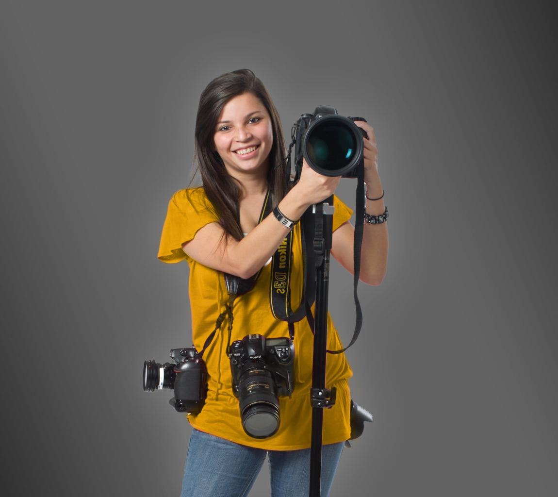年轻女子手持多台相机.