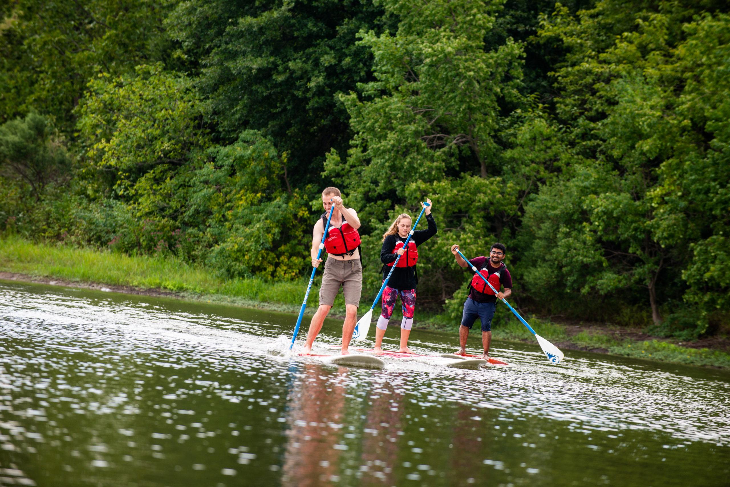 Students paddle boarding