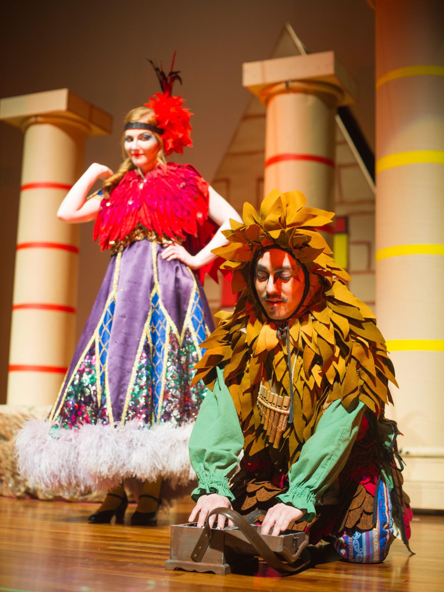 Man and woman wearing costumes on stage of theatrical performance